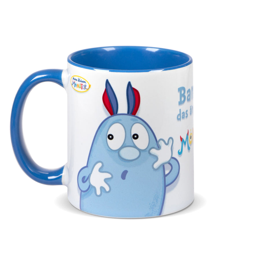 Keramiktasse mit blauem Henkel und blauem Innenrand, bedruckt mit der Figur „Bammel“, einem blauen, ängstlichen Monster mit roten Ohren und Schuhen.